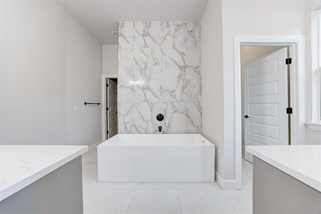 bathroom with a tub, baseboards, marble finish floor, and vanity