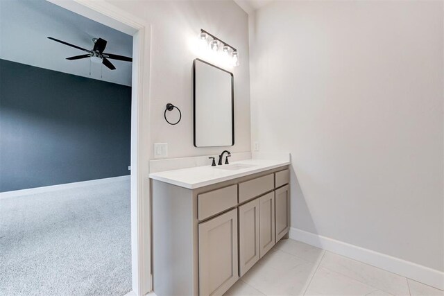 bathroom with baseboards, a ceiling fan, and vanity