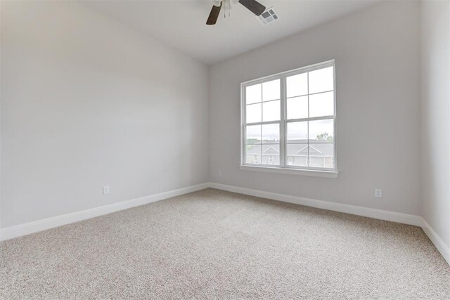 empty room featuring light colored carpet, baseboards, ceiling fan, and visible vents