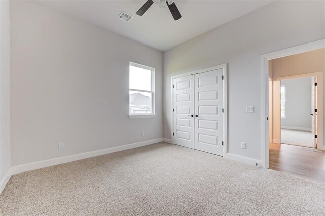 unfurnished bedroom with visible vents, baseboards, a closet, and light carpet
