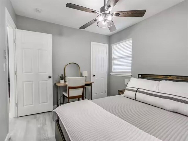 bedroom with a ceiling fan and light wood-type flooring