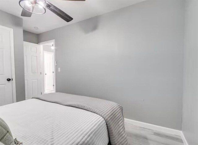 bedroom with baseboards, ceiling fan, and light wood-type flooring