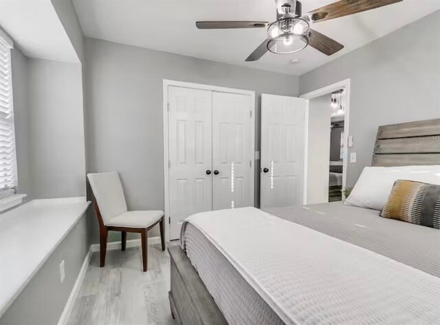 bedroom with a ceiling fan, baseboards, light wood finished floors, and a closet