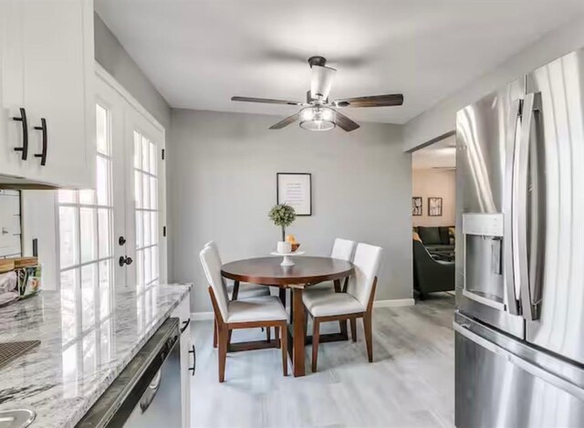 dining space featuring french doors, ceiling fan, baseboards, and light wood-type flooring