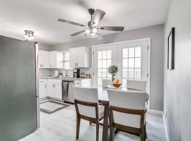 kitchen featuring ceiling fan, appliances with stainless steel finishes, tasteful backsplash, light countertops, and white cabinetry