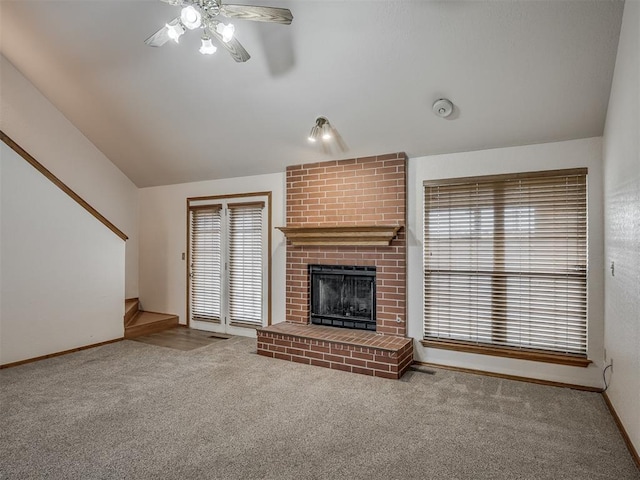 unfurnished living room featuring a ceiling fan, a fireplace, vaulted ceiling, carpet floors, and baseboards