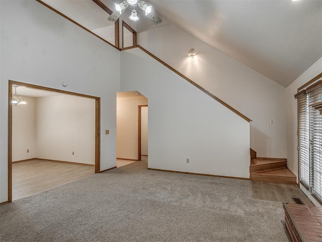 unfurnished living room with carpet floors, a ceiling fan, high vaulted ceiling, and baseboards