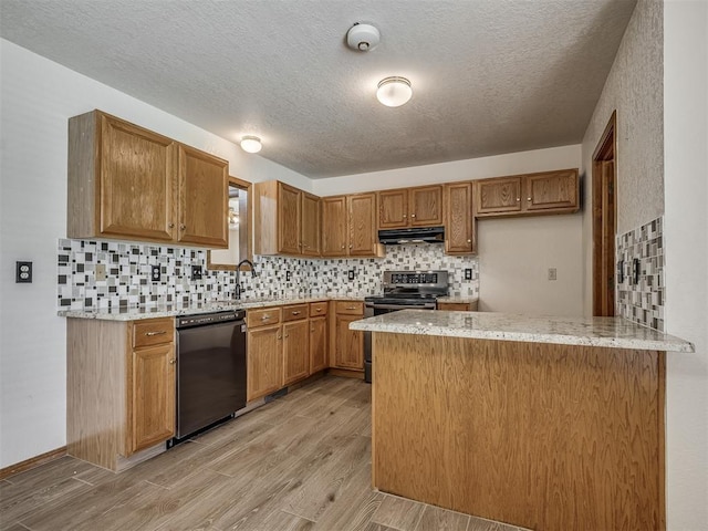 kitchen with light stone countertops, stainless steel range with electric stovetop, dishwasher, a peninsula, and under cabinet range hood