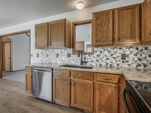 kitchen with stainless steel dishwasher, a sink, brown cabinetry, and backsplash