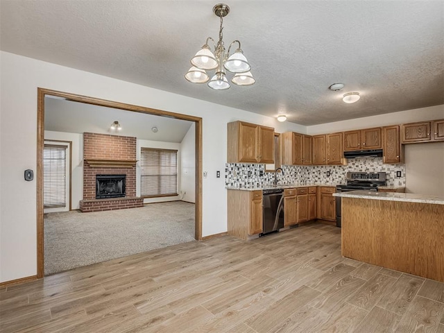 kitchen with light wood-style floors, light countertops, brown cabinetry, stainless steel appliances, and under cabinet range hood