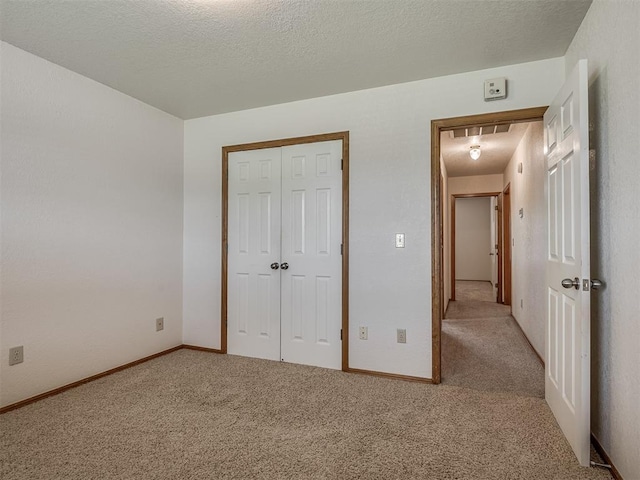unfurnished bedroom featuring baseboards, carpet, and a closet