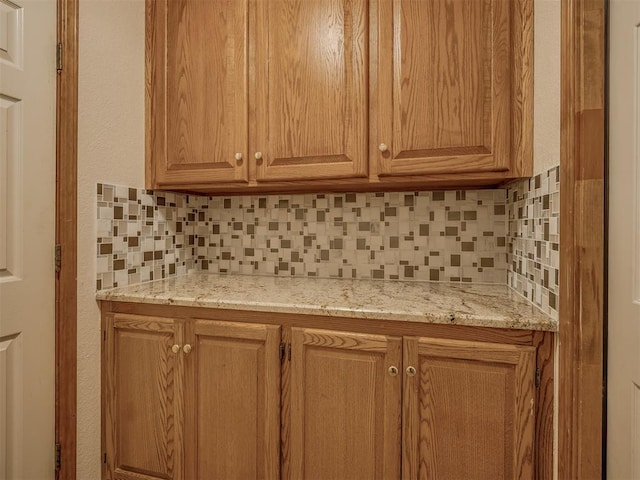 kitchen with decorative backsplash and light stone countertops