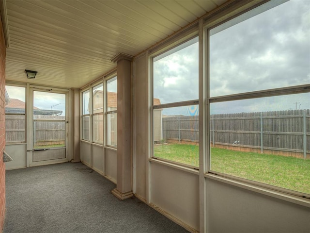 unfurnished sunroom with carpet floors and a wealth of natural light