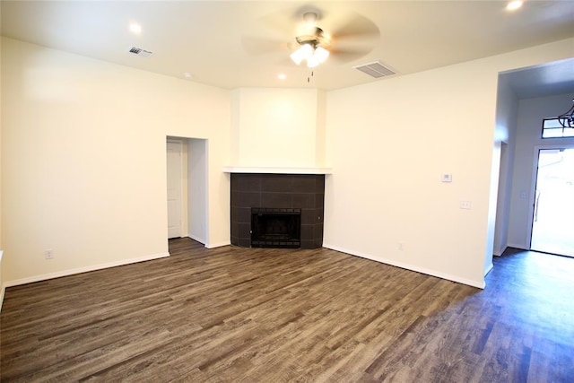unfurnished living room with a ceiling fan, dark wood-style floors, a tile fireplace, and visible vents