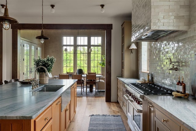 6509 NE 97th St, Oklahoma City, OK 73151 - kitchen with custom exhaust hood, tasteful backsplash, light wood-style flooring, a center island with sink, and pendant lighting