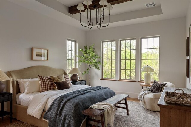 6509 NE 97th St, Oklahoma City, OK 73151 - bedroom featuring a chandelier, multiple windows, and wood finished floors