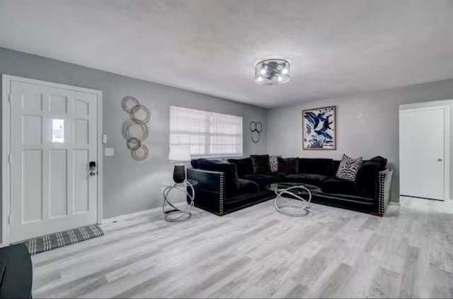 living area featuring baseboards and wood finished floors