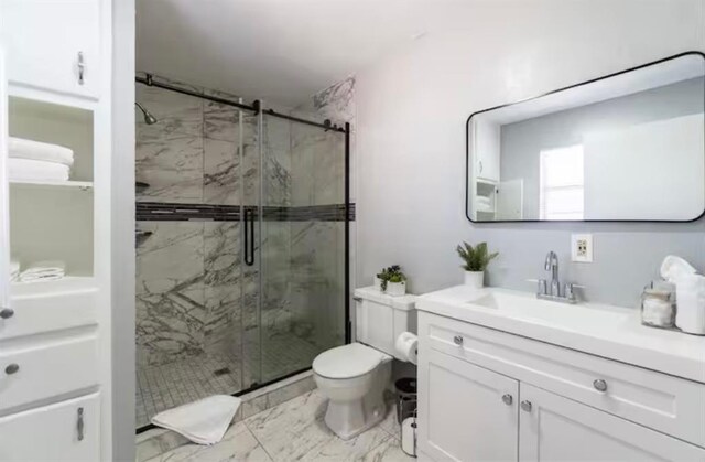 bathroom featuring toilet, a marble finish shower, marble finish floor, and vanity