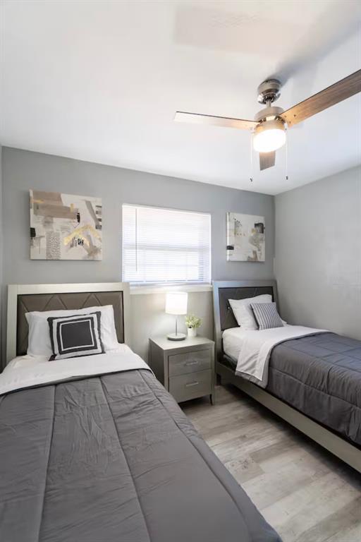 bedroom with a ceiling fan and light wood-type flooring