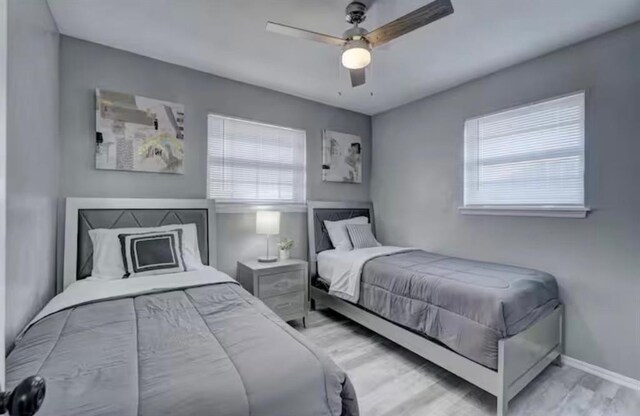 bedroom featuring baseboards, ceiling fan, and wood finished floors