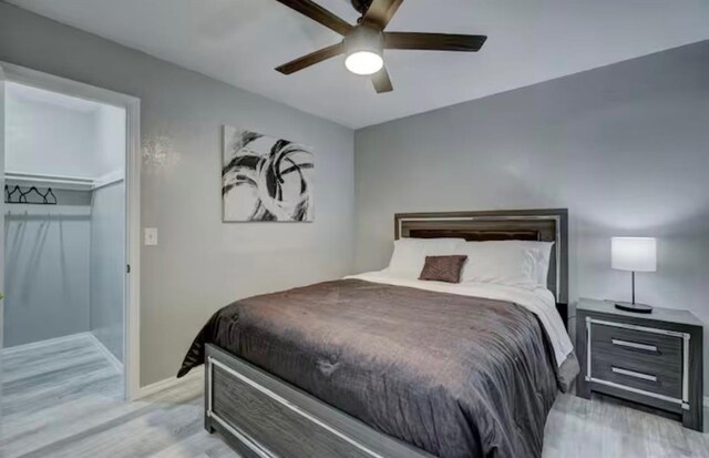 bedroom with baseboards, a ceiling fan, and light wood-style flooring