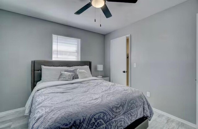 bedroom featuring baseboards, ceiling fan, and wood finished floors