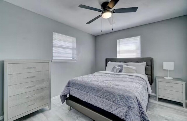 bedroom with baseboards, a ceiling fan, and wood finished floors