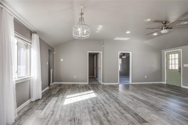 20318 State Highway 39, Purcell, OK 73080 - unfurnished living room with baseboards, vaulted ceiling, wood finished floors, and ceiling fan with notable chandelier