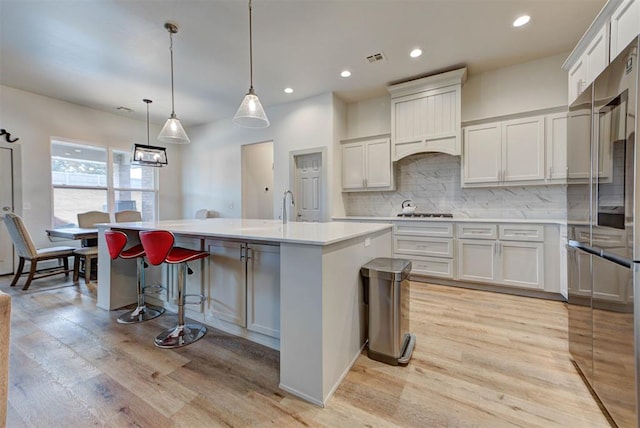 9600 Sultans Water Way, Yukon, OK 73099 - kitchen featuring high end refrigerator, tasteful backsplash, light wood finished floors, light countertops, and recessed lighting