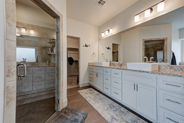 9600 Sultans Water Way, Yukon, OK 73099 - full bathroom featuring a shower stall, tile patterned flooring, double vanity, and a spacious closet