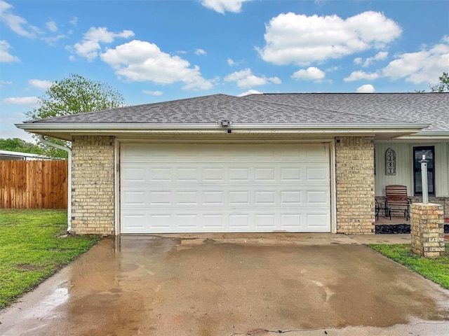 garage featuring fence and concrete driveway
