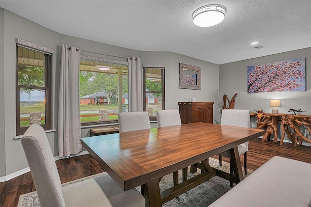 dining space featuring a textured ceiling, baseboards, visible vents, and wood finished floors