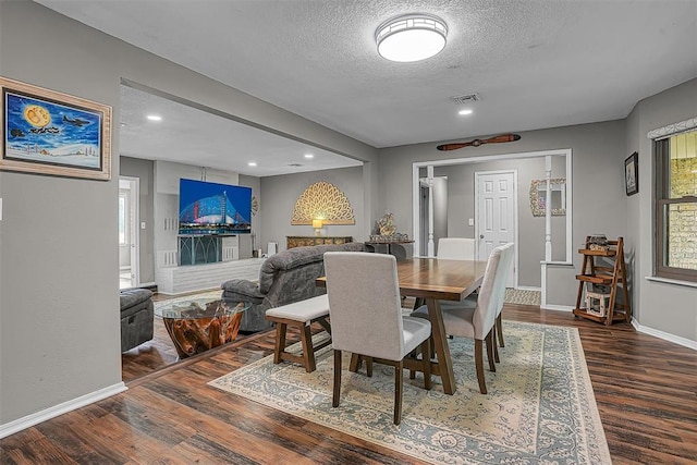 dining space featuring a textured ceiling, recessed lighting, baseboards, wood finished floors, and visible vents