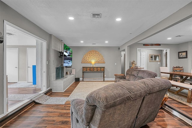 living room featuring recessed lighting, wood finished floors, and visible vents