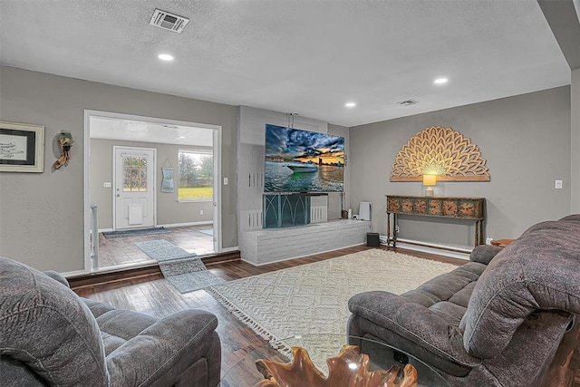 living area featuring recessed lighting, baseboards, visible vents, and wood finished floors