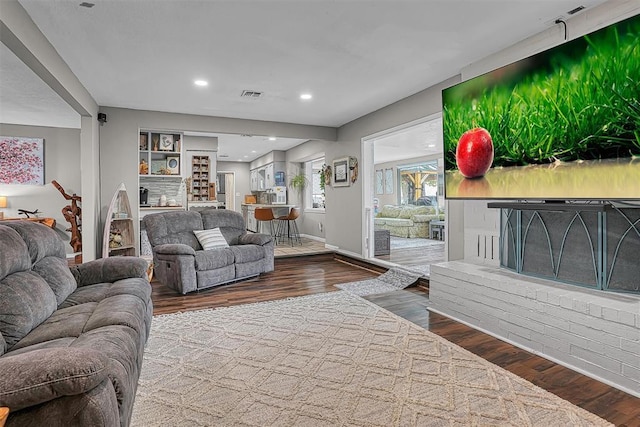 living room with recessed lighting, baseboards, visible vents, and wood finished floors