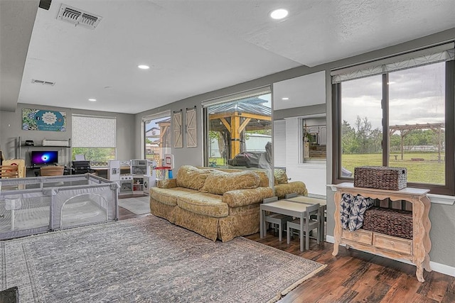 living room with visible vents, recessed lighting, plenty of natural light, and wood finished floors