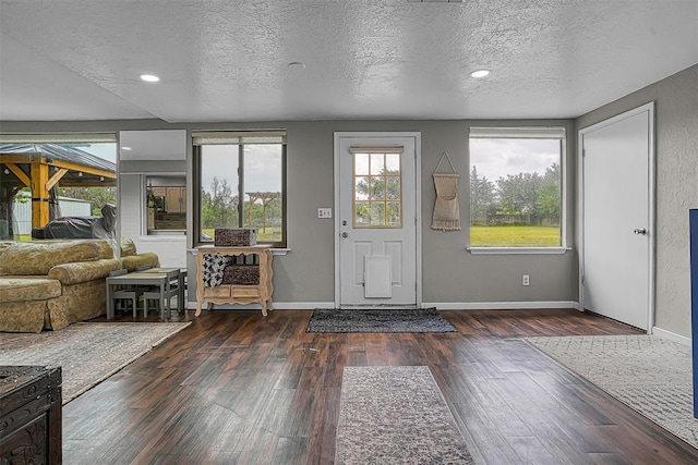 entrance foyer featuring baseboards, recessed lighting, a textured ceiling, and wood finished floors