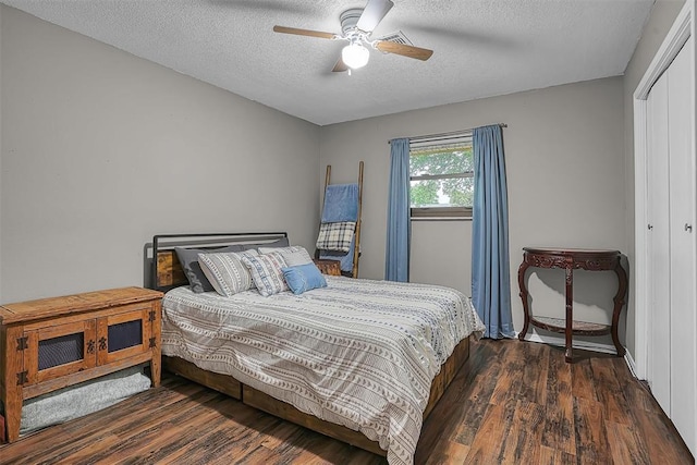bedroom featuring a ceiling fan, a textured ceiling, wood finished floors, and a closet