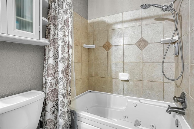 full bathroom with a textured wall, a combined bath / shower with jetted tub, and toilet