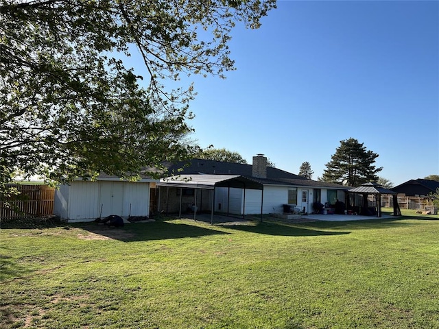 view of yard with a storage shed, an outbuilding, a gazebo, fence, and a patio