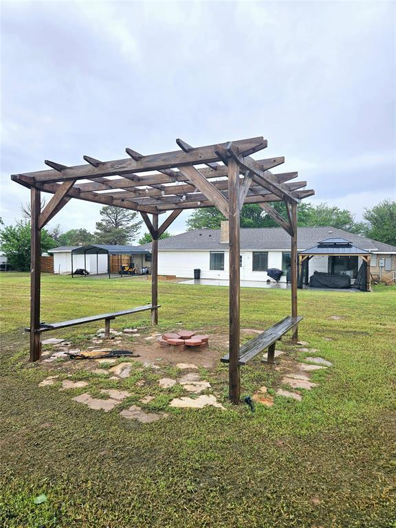 view of yard with a pergola and an outdoor structure