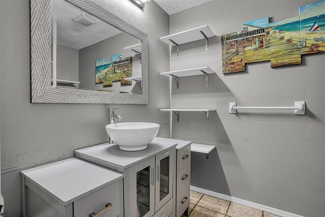 20428 E County Road 1567, Altus, OK 73521 - bathroom featuring tile patterned flooring, vanity, baseboards, and a textured ceiling