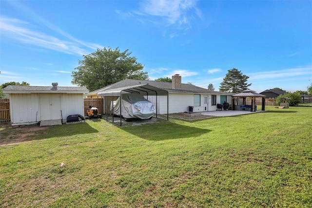 20428 E County Road 1567, Altus, OK 73521 - back of house featuring a detached carport, a gazebo, a shed, an outdoor structure, and a chimney