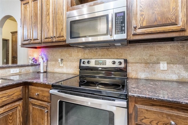 1904 Timber Xing, Yukon, OK 73099 - kitchen featuring appliances with stainless steel finishes, backsplash, and brown cabinets