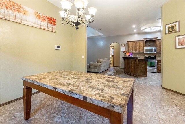 1904 Timber Xing, Yukon, OK 73099 - dining area featuring arched walkways, baseboards, an inviting chandelier, and light tile patterned floors