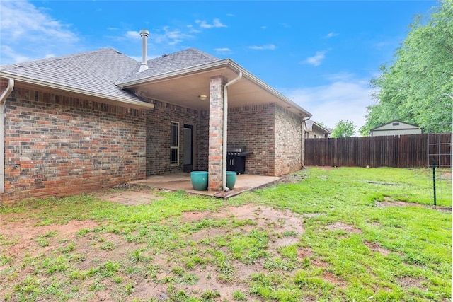 1904 Timber Xing, Yukon, OK 73099 - rear view of property with a shingled roof, brick siding, a fenced backyard, a patio, and a yard