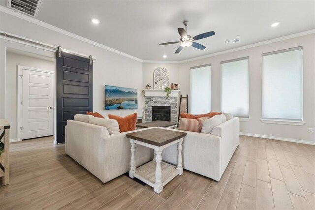 living area featuring ceiling fan, light wood finished floors, and visible vents