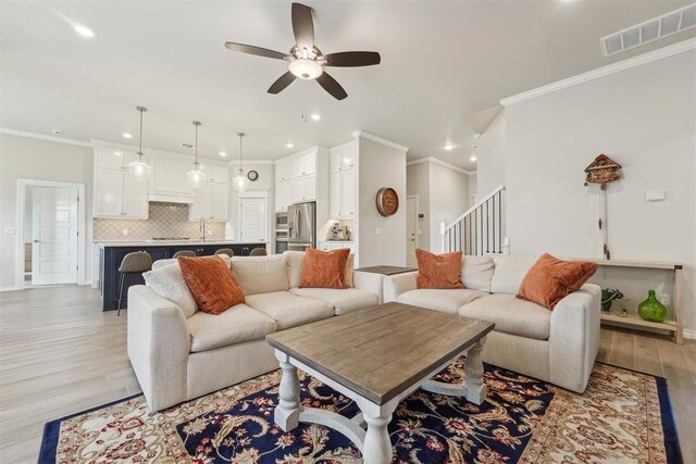 living room with ornamental molding, a ceiling fan, recessed lighting, and visible vents
