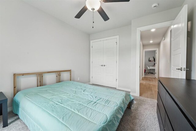 bedroom featuring a closet, a ceiling fan, baseboards, and light carpet